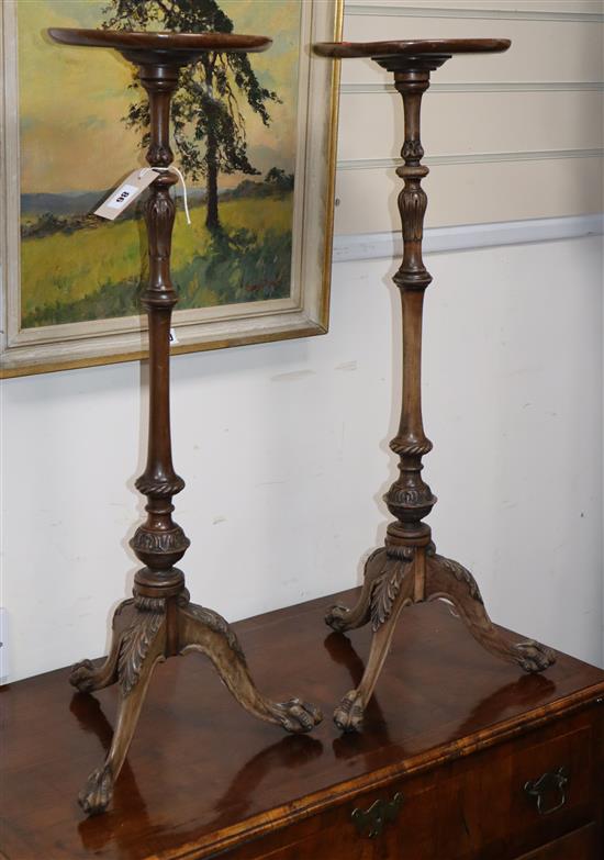 A pair of George I style carved mahogany tripod candle stands, Diameter 22cm, H.77cm